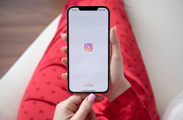 Ilustrasi perempuan membuka aplikasi Instagram. Foto: DenPhotos/Shutterstock