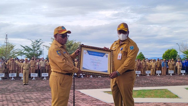 Kepala Bappeda Papua Barat Dance Sangkek menyerahkan penghargaan atas  Penyelenggaraan Penilaian Kinerja dan Aksi Konvergensi Penurunan Stunting Tahun 2021