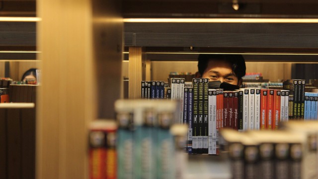 Seorang pengunjung mencari buku bacaan di Perpustakaan Jakarta Taman Ismail Marzuki, Jakarta, Senin (11/7/2022). Foto: Budi Prasetio/ANTARA FOTO