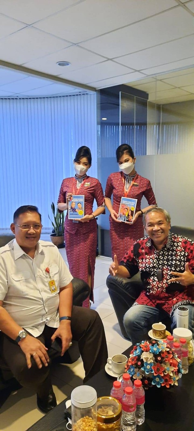 Capt Daniel Putut (kiri), Dr Aqua Dwipayana (kanan), bersama dua pramugari Lion Air Group yang memegang buku "super best seller". Foto: dok