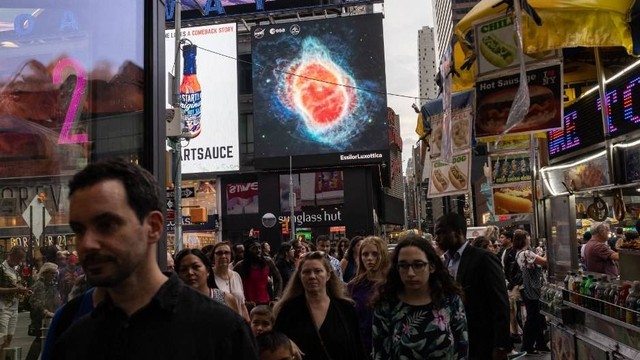 Gambar yang diambil oleh Teleskop Luar Angkasa James Webb ditampilkan di layar di Times Square pada Selasa (12/7/2022). Foto: Yuki Iwamura/AFP