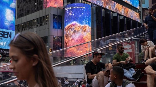 Gambar yang diambil oleh Teleskop Luar Angkasa James Webb ditampilkan di layar di Times Square pada Selasa (12/7/2022). Foto: Yuki Iwamura/AFP