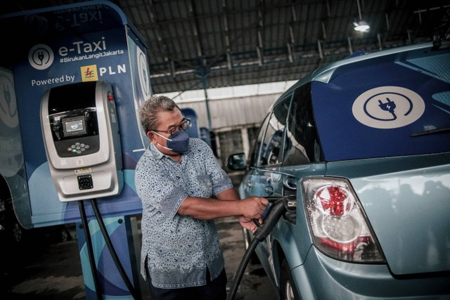 Pengemudi taksi Bluebird sedang mengisi daya untuk taksi listriknya di tempat pengisian daya baterai Blue Bird Group, Mampang, Jakarta Selatan, Rabu (13/7/2022). Foto: Jamal Ramadhan/kumparan