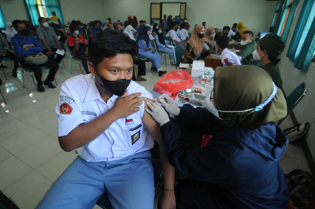 Tenaga kesehatan menyuntikan dosis vaksin COVID-19 kepada siswa saat kegiatan vaksinasi COVID-19 di SMA Negeri 1 Klaten, Jawa Tengah, Rabu (13/7/2022). Foto: Aloysius Jarot Nugroho/Antara Foto