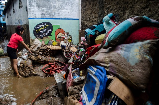 Warga menumpuk barang dan perabotan yang terendam lumpur akibat banjir bandang Sungai Cimanuk di Garut, Jawa Barat, Sabtu (16/7/2022).  Foto: Novrian Arbi/ANTARA FOTO