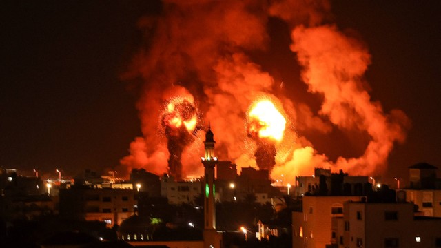 Kebakaran terlihat setelah serangan udara Israel di kota Gaza, Palestina, Sabtu (16/7/2022). Foto: Mahmud Hams/AFP