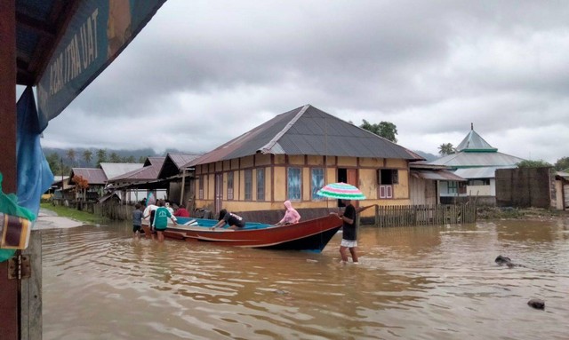 Air laut yang meluap di pemukiman warga dan menutup ruas jalan di Desa Kou, Kecamatan Mangoli Timur, Kepulauan Sula. Foto: Istimewa