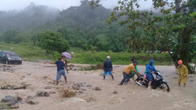 Jalan Trans Sulawesi yang tertutup material Sungai Batutuar di Desa Blongko, Kabupaten Minahasa Selatan