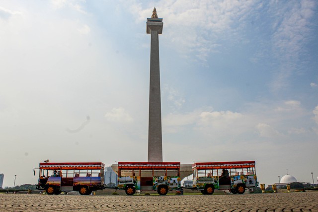 Tugu Monas bersama bus pengumpan pengunjung untuk ke depan gerbang masuk Tugu Monas. Selasa, 12 Juli 2022. Foto: Lutfi Sheykal