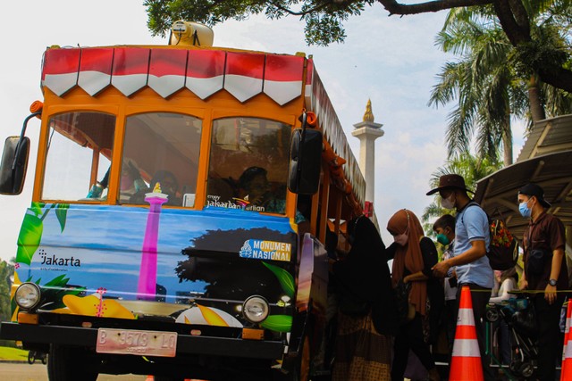 Pengunjung yang sedang menaiki bus, untuk memasuki Tugu Monas. Selasa, 12 Juli 2022. Foto: Lutfi Sheykal