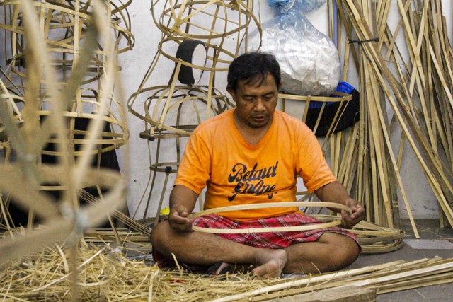 Pekerja seni Ondel-ondel seang melengkungkan bambu yang sudah di pipih. Foto: Lutfi Sheykal