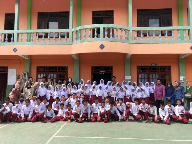 Mahasiswa KKN-PPM UGM subunit 3 dan subunit 4 (Unit YO-042) Berbah melakukan foto bersama siswa-siswi kelas 4, 5, dan 6 setelah pelaksanaan kegiatan sosialisasi di SD Muhammadiyah Bulu, Berbah (Selasa, 19/07/2022). Foto: Hendra Noviantara (Pribadi)