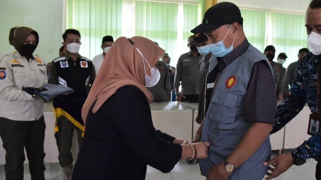 Bupati Sleman, Kustini Sri Purnomo, saat mengukuhkan kelompok Jaga Warga Padukuhan Plosokuning V Kalurahan Minomartani dan Padukuhan Penen Kalurahan Donoharjo di kantor Kapanewon Ngaglik, Rabu (20/7/2022). Foto: istimewa