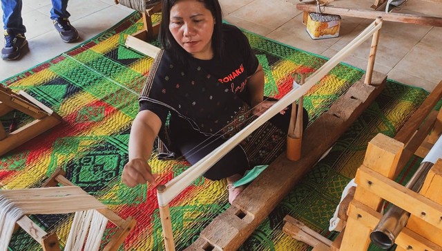 Perempuan perajin tenun yang merupakan mitra Tobatenun, menenun di rumah komunitas Jabu Bonang dan Jabu Borna di Pematangsiantar, Sumatera Utara, pada Kamis (14/07/2022). Foto: Judith Aura/kumparan