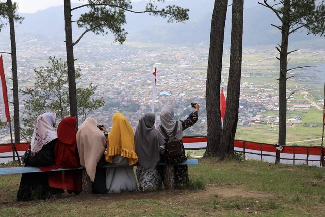 Wisatawan menikmati pemandangan alam di kawasan wisata Bur Telege di Aceh Tengah. Foto: Suparta/acehkini