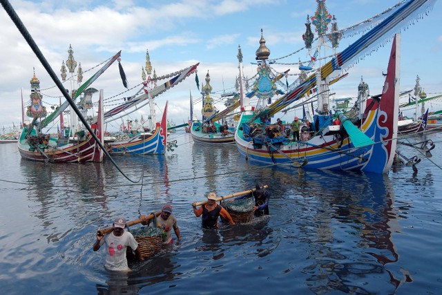 Sejumlah nelayan memanggul keranjang berisi ikan hasil tangkapan di Pelabuhan Perikanan Nusantara Pengambengan, Jembrana, Bali, Kamis (21/7/2022). Foto: Nyoman Hendra Wibowo/Antara Foto