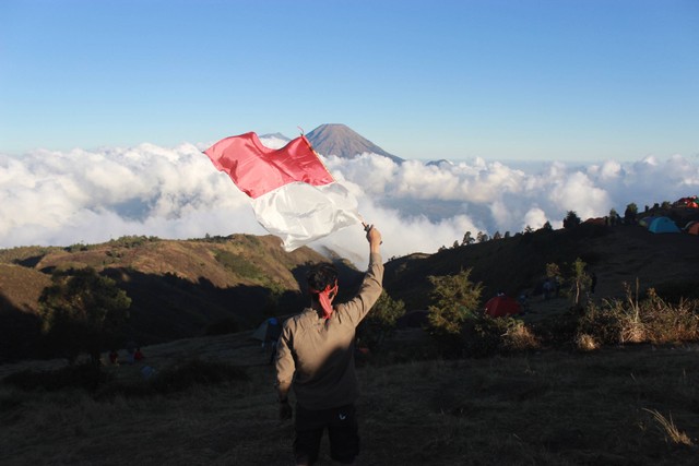 Ilustrasi mengibarkan bendera Indonesia saat Hari Anak Nasional. Foto: Unsplash