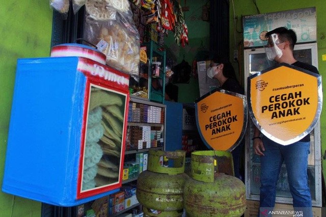 Dua relawan melakukan edukasi tentang bahaya merokok kepada pedagang saat kampanye "Cegah Perokok Anak". Fhoto : ANTARA FOTO/Muhammad Iqbal