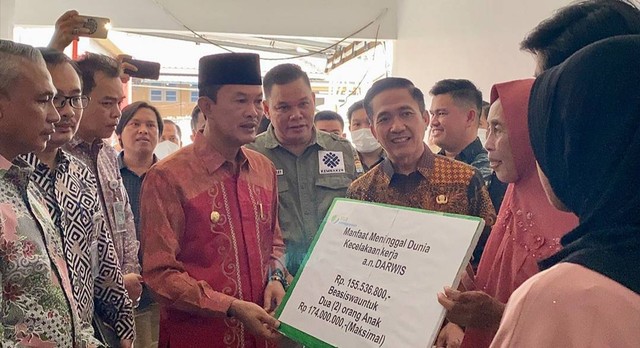 Wali Kota Palembang, Harnojoyo, didampingi Kantor BPJamsostek Cabang Palembang, Moch Faisal, saat menyerahkan santunan kepada keluarga Darwis. (dok. Dinas Kominfo)