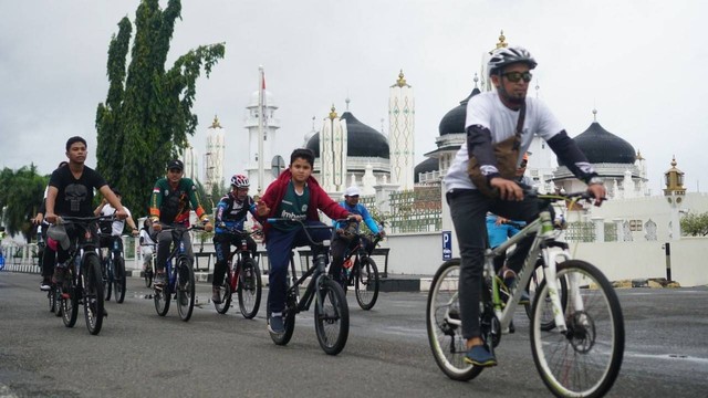 Para pesepeda melewati Masjid Raya Baiturrahman Banda Aceh. Foto: Disbudpar Aceh 