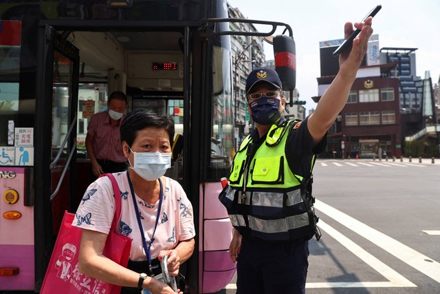 Penumpang bus diminta untuk mencari perlindungan selama latihan serangan udara bernama Wan An, latihan 30 menit, pengingat meningkatnya ancaman militer China. Foto: REUTERS/Ann Wang