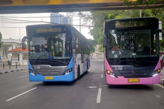 Bus TransJakarta pink (kanan) yang diperuntukkan untuk pelanggan wanita melintas di Pasar Baru, Jakarta Pusat, Jakarta pada Senin (25/07/2022). Foto: Hendri Sukma Indrawan/Antara