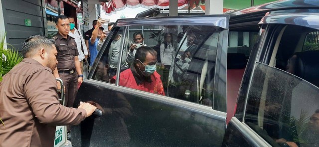 Kades Senibung tersangka dugaan korupsi dana desa masuk ke mobil yang akan membawanya ke Lapas Sintang. (Foto: Yusrizal/Hi! Pontianak)