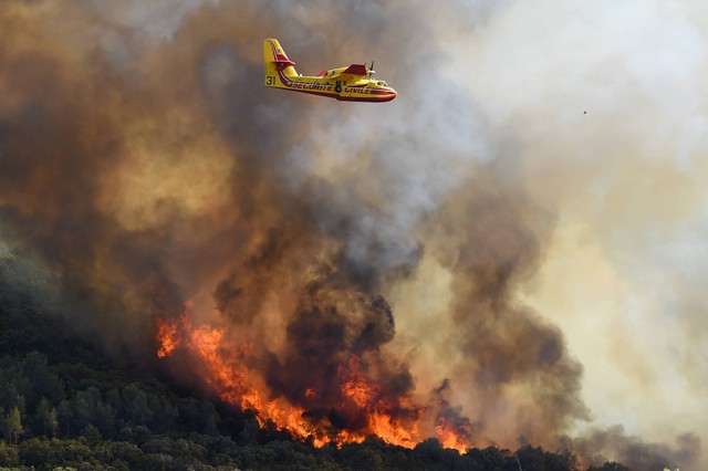 Pesawat pemadam kebakaran dikerahkan di dekat Gignac, Prancis selatan, yang belum padam pada Selasa (26/7/2022). Foto: Sylvain Thomas/AFP