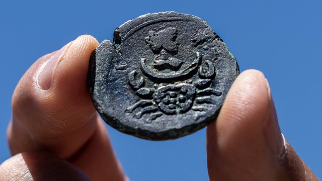 Sebuah koin perunggu langka berusia hampir 1.850 tahun yang ditemukan di lepas pantai kota Haifa Israel dipajang di kantor Otoritas Barang Antik Israel di Yerusalem, Selasa (26/7/2022). Foto: Tsafrir Abayov/AP Photo