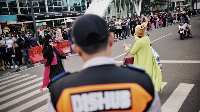 Petugas mengatur lalu lintas di area 'Citayam Fashion Week', di Dukuh Atas, Sudirman, Jakarta, Rabu (27/7/2022). Foto: Jamal Ramadhan/kumparan