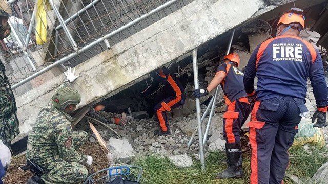 Awak darurat melakukan operasi penyelamatan di luar gedung yang runtuh saat gempa, di La Trinidad, Benguet, Filipina, Rabu (27/7/2022). Foto: Biro Proteksi Kebakaran/Handout via REUTERS