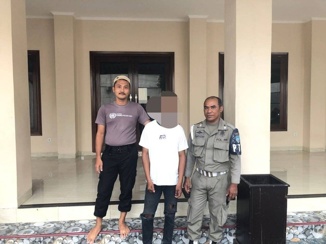 Anggota Satpol PP Kota Ternate menyerahkan juru parkir liar bernama Mufri San ke Binas Polda Maluku Utara. Foto: Istimewa