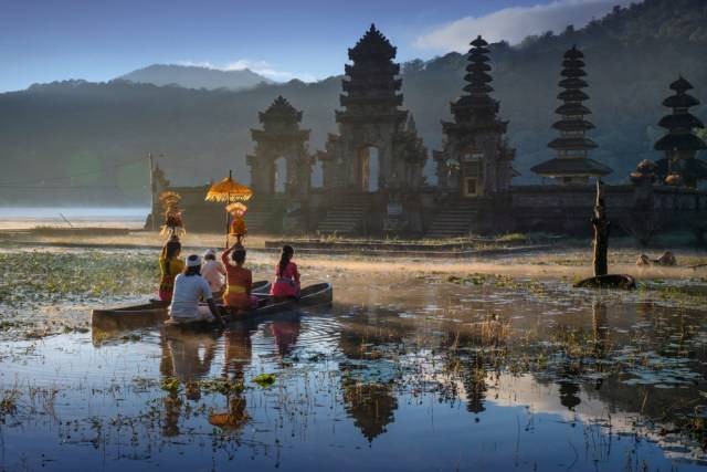 Sebuah keluarga tengah mengarungi danau menuju Pura Tamblingan di Buleleng, Bali Foto: Shutter Stock