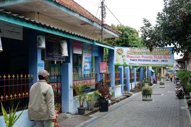 Warga melintasi TK Aisyiyah Bustanul Athfal (TK ABA) Kauman, Kota Yogyakarta yang merupakan TK tertua di Indonesia. Foto: Arfiansyah Panji Purnandaru/kumparan