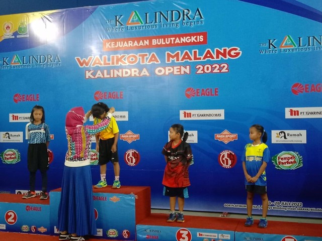 Istri Wali Kota Malang, Widayati Sutiaji, mengalungkan medali pada atlit cilik Bulu Tangkis kategori pemula putri. foto/ M Sholeh