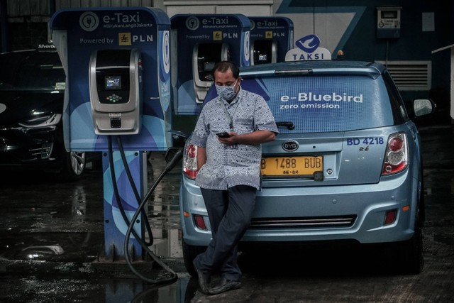 Pengemudi taksi Bluebird sedang menunggu saat mengisi daya untuk taksi listriknya di tempat pengisian daya baterai di Blue Bird Group, Mampang, Jakarta Selatan, Rabu (13/7/2022). Foto: Jamal Ramadhan/kumparan