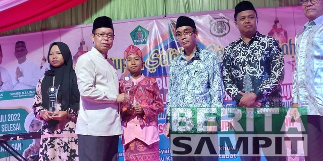 PENYERAHAN PIALA : Bupati Katingan Sakariyas saat menyerahkan Piala kesalah satu Juara Seni Qosidah, Sabtu 30 Juli 2022. (KAWIT/BERITA SAMPIT).