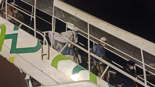 Jemaah haji kloter pertama asal Aceh turun dari pesawat setiba di Bandara Sultan Iskandar Muda (SIM), Blang Bintang, Aceh Besar, Selasa (26/7/2022) malam. Foto: Dok. PPIH Aceh