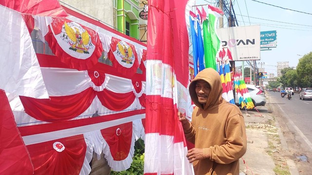 Edi pedagang bendera dan umbul-umbul di Jalan Teuku Umar, Kedaton, Bandar Lampung. | Foto: Sinta Yuliana/Lampung Geh