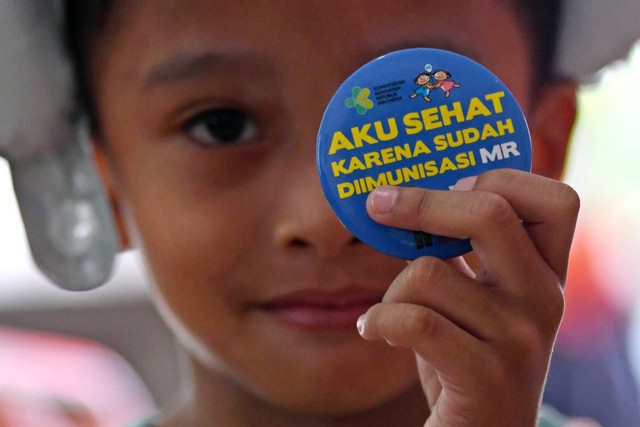 Seorang anak menunjukkan pin tanda telah divaksin campak rubella dalam Bulan Imuniasi Anak Nasional (BIAN) di Ruang Publik Terpadu Ramah Anak (RPTRA) III Tanah Abang, Jakarta, Kamis (4/8/2022). Foto: Aditya Pradana Putra/ANTARA FOTO