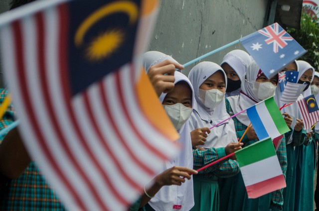 Sejumlah pelajar sekolah dasar mengibarkan bendera Delegasi sejumlah negara peserta Konferensi Internasional Urban 20 (U20) saat kunjungan ke urban farming Buruan Sae, Bandung, Jawa Barat, Kamis (4/8/2022). Foto: Novrian Arbi/ANTARA FOTO