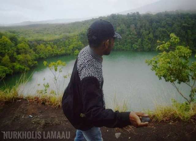 Seorang pengunjung mengambil ancang-ancang melontarkan batu ke arah Danau Tolire Besar di Kelurahan Takome, Kecamatan Ternate Barat, Kota Ternate, Maluku Utara. Foto: Nurkholis Lamaau/cermat
