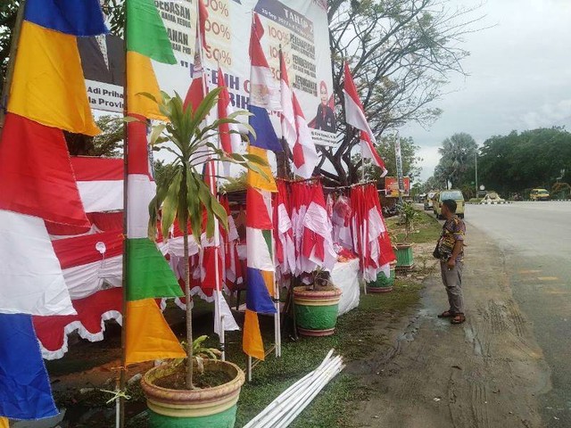Imam di depan bendera yang dijualnya di kawasan Simpang RSUD HM Sani Karimun. (Foto: Edo/batamnews)