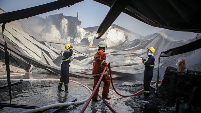 Petugas pemadam kebakaran melakukan proses pendinginan saat kebakaran gudang penyimpanan plastik di Kosambi, Kabupaten Tangerang, Banten, Jumat (5/8/2022). Foto: Fauzan/ANTARA FOTO