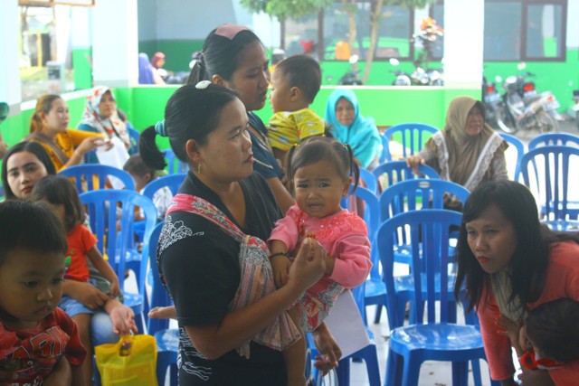 Seorang ibu menggendong anak yang sedang meangis. Dokumentasi pribadi.jpg