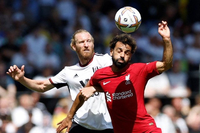 Pemain Liverpool Mohamed Salah beraksi dengan pemain Fulham Tim Ream di Stadion Craven Cottage, London, Inggris, Sabtu (6/8/2022). Foto: Action Images via Reuters/Peter Cziborra