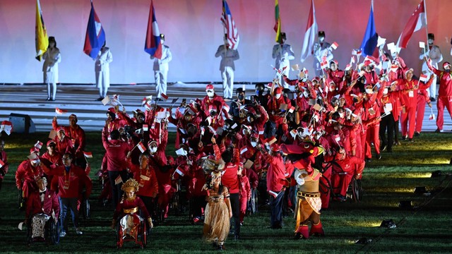 Kontingen Indonesia berjalan sambil membawa bendera dan melambaikan tangan pada penutupan ASEAN Para Games 2022 di Stadion Manahan, Solo, Jawa Tengah, Sabtu (6/8/2022). Foto: Hendra Nurdiyansyah/ANTARA FOTO