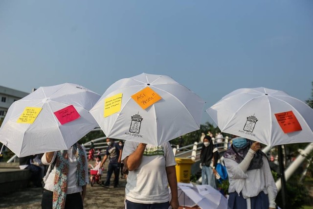 Seorang peserta menempelkan pesan pada payung tentang pentingnya menyusui di Alun-Alun Kota Depok, Depok, Jawa Barat, Minggu (7/8/2022).  Foto: Asprilla Dwi Adha/ANTARA FOTO