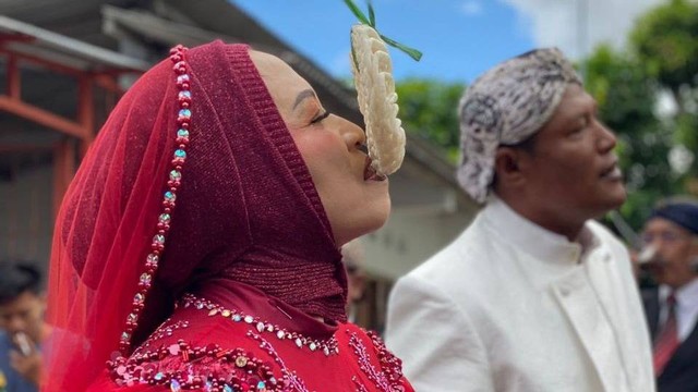 Pasangan pengantin yang mengikuti lomba makan kerupuk, Minggu (7/8/2022). Foto: istimewa