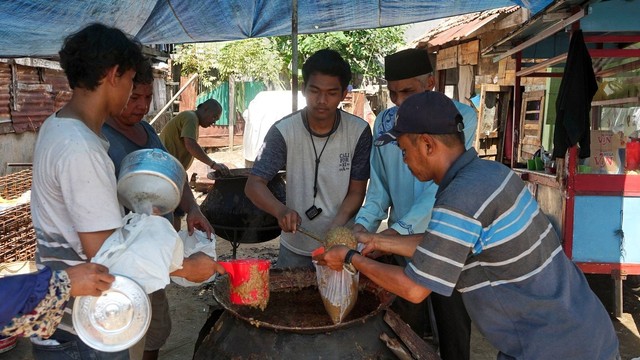 Proses pembagian bubur yang juga dilakukan di tempat memasak oleh pengurus masjid suro, Senin (8/8) Foto: abp/Urban Id